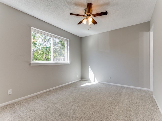 unfurnished room with ceiling fan, carpet floors, and a textured ceiling