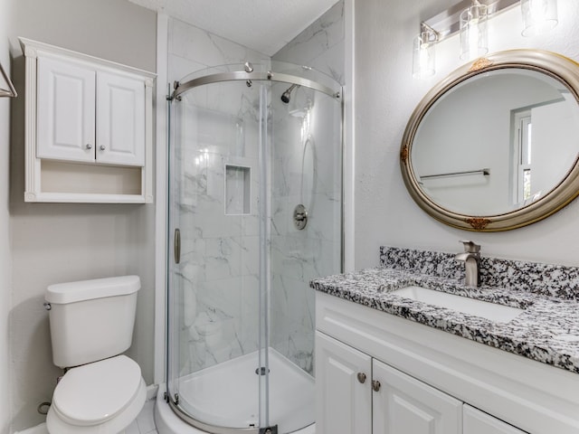 bathroom featuring a shower with door, vanity, a textured ceiling, and toilet