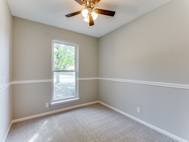 carpeted empty room with ceiling fan and a textured ceiling