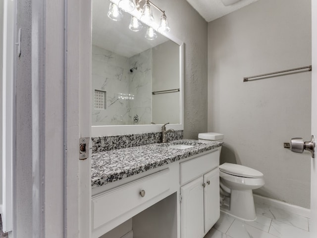 bathroom with vanity, toilet, and tiled shower