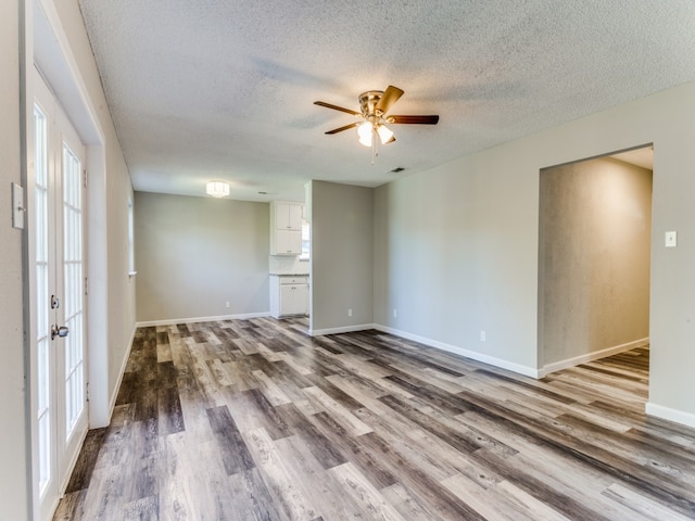 empty room with hardwood / wood-style floors, ceiling fan, a textured ceiling, and french doors