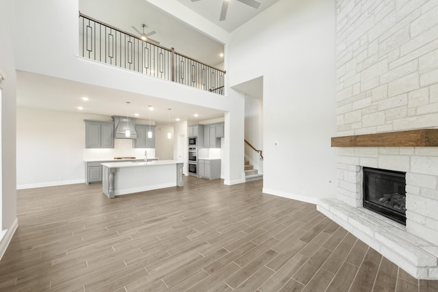 116 Harlan Ct, Aledo, TX 76008 - unfurnished living room featuring a ceiling fan, a fireplace, a sink, stairway, and baseboards