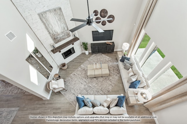 living room with a high ceiling, ceiling fan, and hardwood / wood-style floors