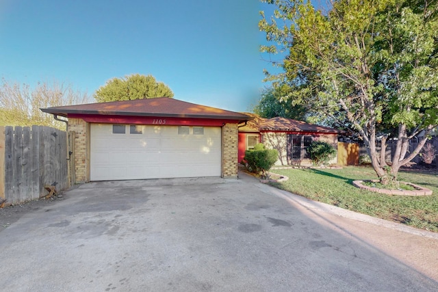 ranch-style home featuring a front yard and a garage