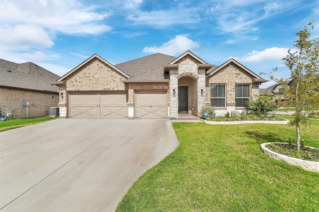 view of front of property featuring central air condition unit, a front yard, and a garage