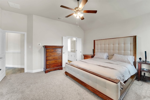 bedroom featuring connected bathroom, light colored carpet, vaulted ceiling, and ceiling fan