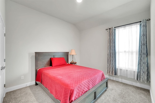 bedroom with light carpet and lofted ceiling