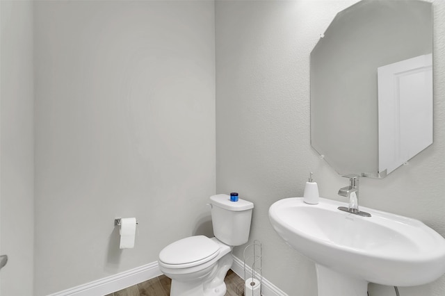 bathroom featuring sink, hardwood / wood-style floors, and toilet