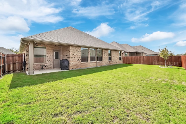 back of house with a yard and a patio