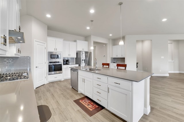 kitchen with a kitchen island with sink, white cabinetry, stainless steel appliances, and range hood