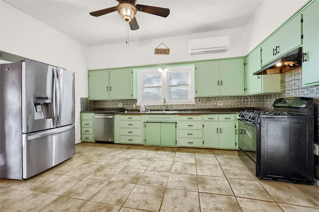 kitchen featuring ceiling fan, a wall unit AC, a textured ceiling, appliances with stainless steel finishes, and green cabinetry