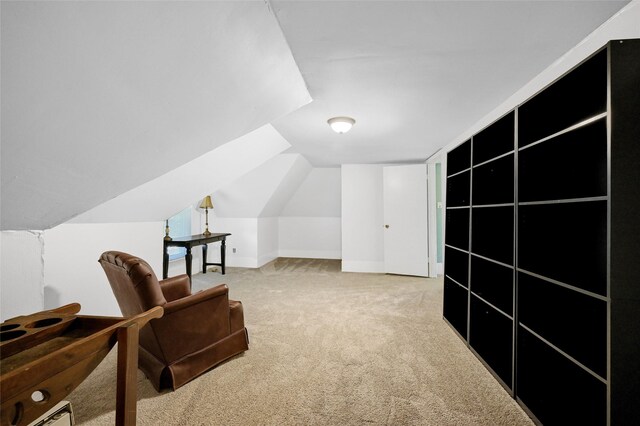 living area featuring light carpet and vaulted ceiling