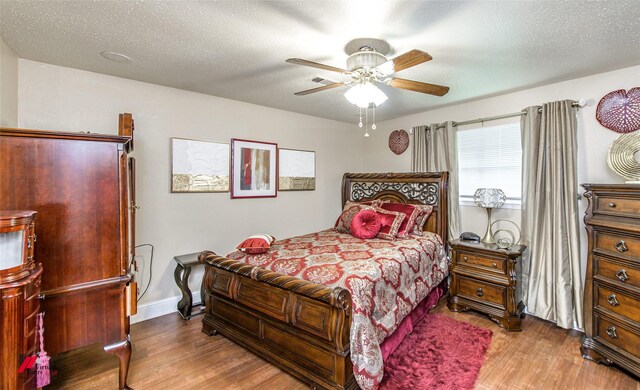 bedroom with wood-type flooring, a textured ceiling, and ceiling fan