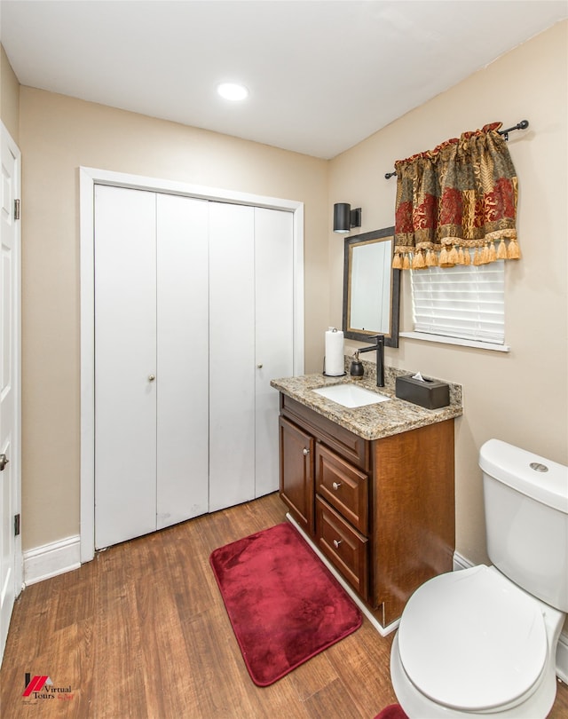 bathroom featuring hardwood / wood-style floors, vanity, and toilet