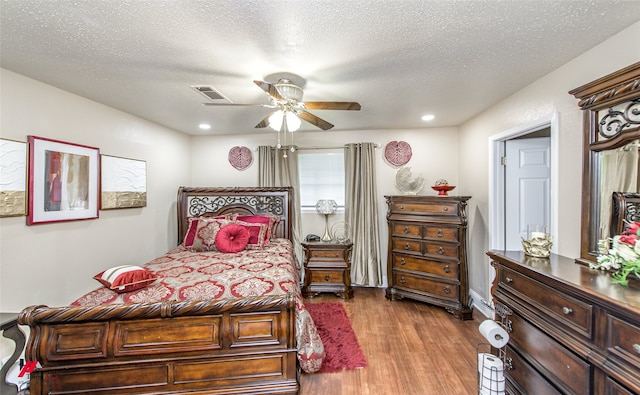 bedroom featuring ceiling fan, a textured ceiling, and light wood-type flooring