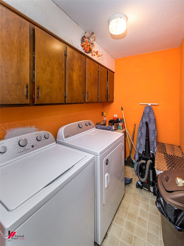 laundry area featuring cabinets, separate washer and dryer, and a textured ceiling