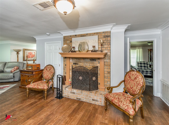 living area with ornamental molding, dark wood-type flooring, and a brick fireplace