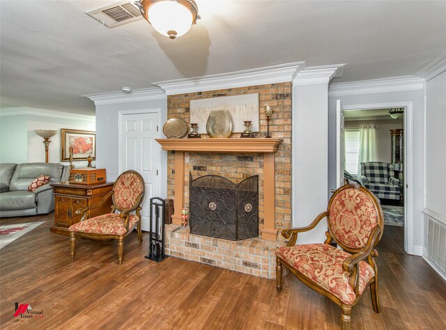 living area with ornamental molding, dark wood-type flooring, and a brick fireplace