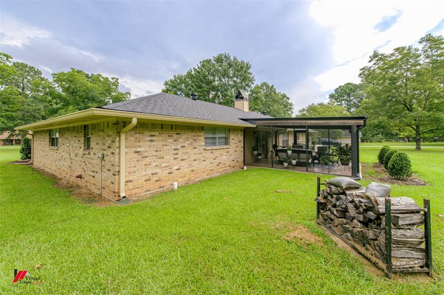 back of property featuring a sunroom and a yard