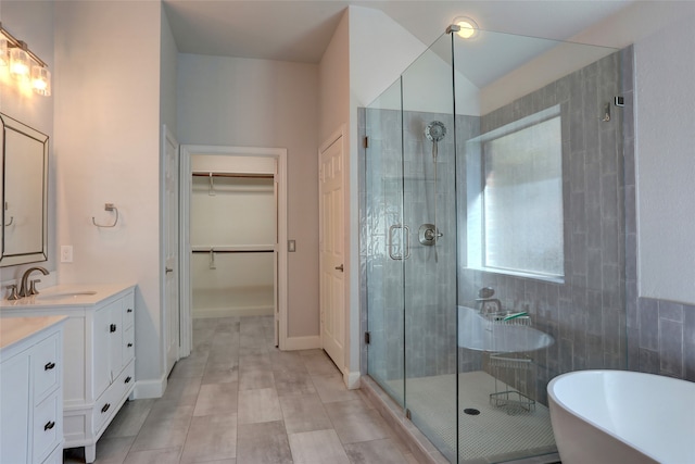 bathroom featuring tile patterned flooring, shower with separate bathtub, and vanity