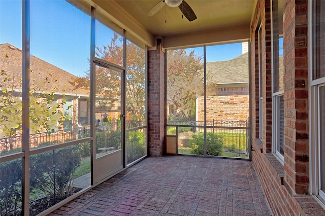 unfurnished sunroom featuring ceiling fan