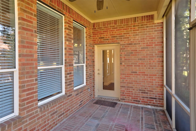 unfurnished sunroom with ceiling fan