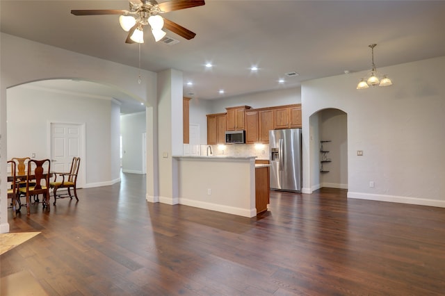 kitchen featuring kitchen peninsula, stainless steel appliances, and dark wood-type flooring