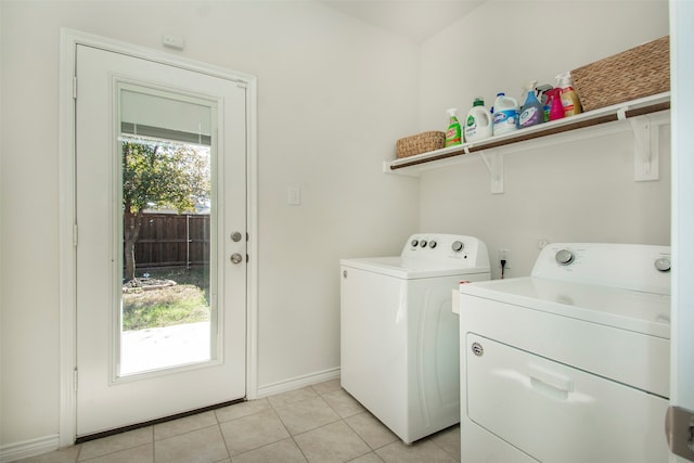 laundry area with independent washer and dryer and light tile patterned floors