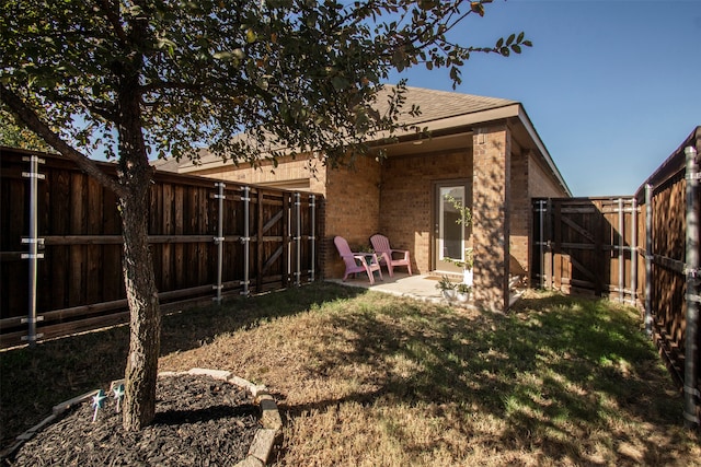 back of house with a lawn and a patio