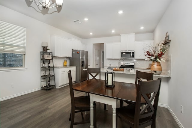 dining space featuring a notable chandelier and dark hardwood / wood-style floors