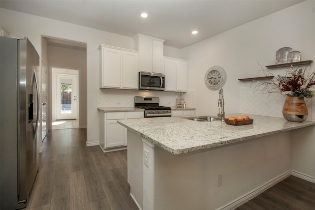 kitchen featuring sink, dark hardwood / wood-style floors, light stone countertops, appliances with stainless steel finishes, and white cabinetry