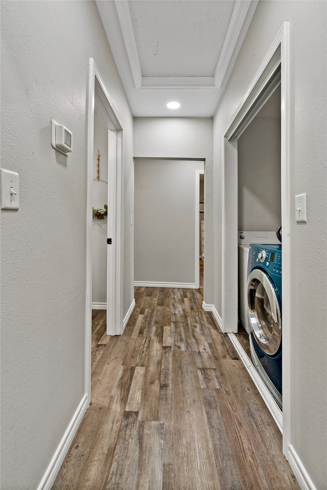 corridor with crown molding, hardwood / wood-style floors, and washer / dryer