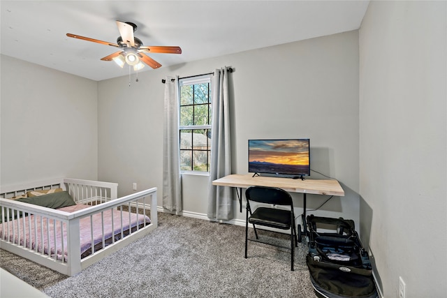 carpeted bedroom featuring ceiling fan and a crib