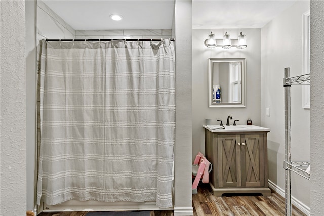 bathroom with hardwood / wood-style floors, vanity, and shower / tub combo with curtain