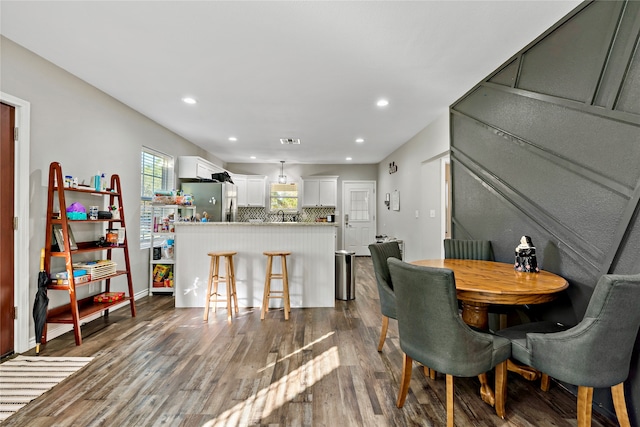 dining space with wood-type flooring