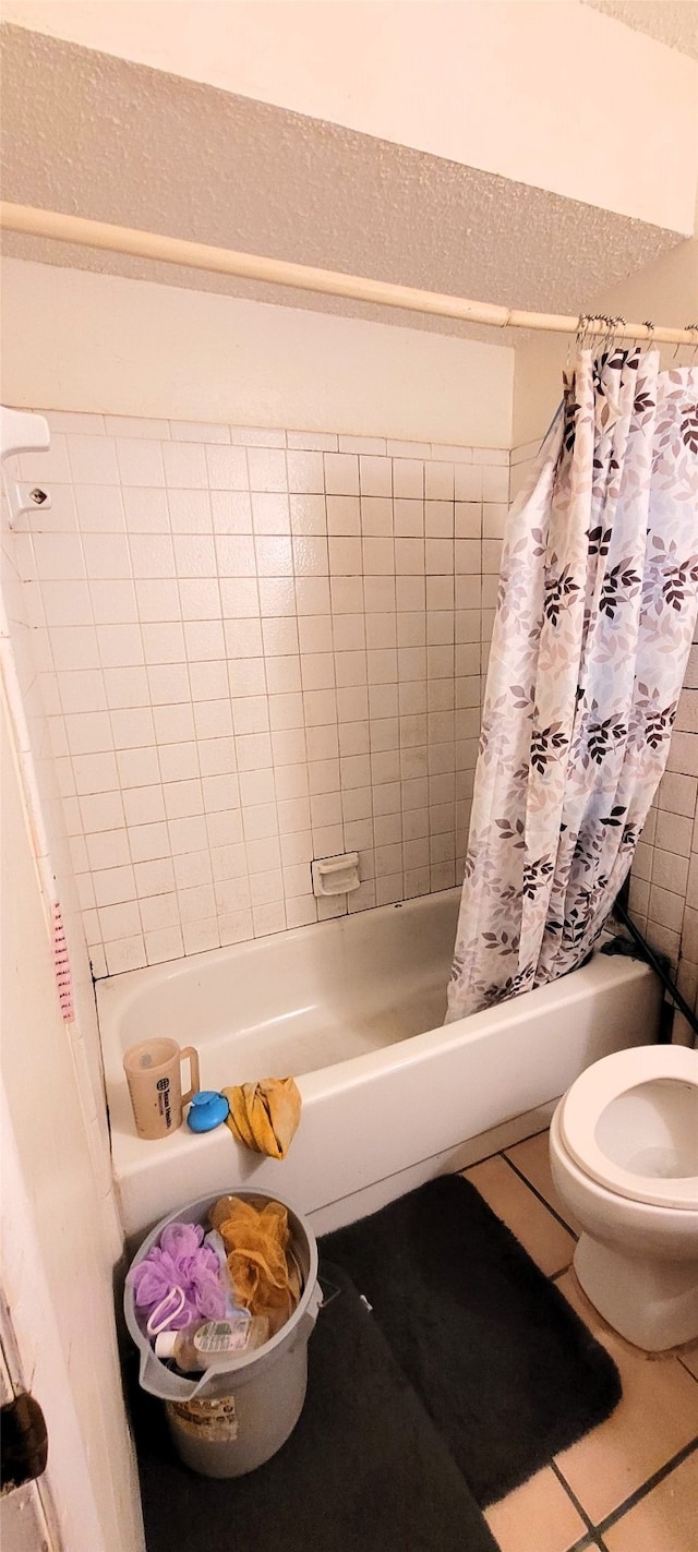 bathroom featuring tile patterned flooring, shower / tub combo with curtain, and toilet