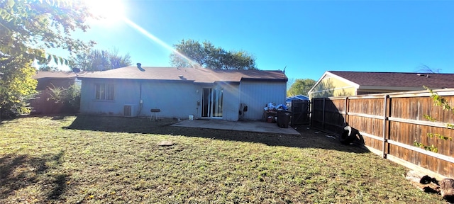 rear view of property featuring central air condition unit, a yard, and a patio