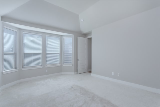 unfurnished bedroom featuring carpet, vaulted ceiling, and ensuite bath