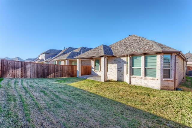 back of property with a patio area and a yard