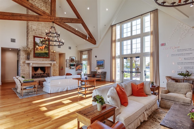 living room featuring high vaulted ceiling, sink, a barn door, beam ceiling, and light hardwood / wood-style floors