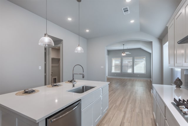 kitchen featuring lofted ceiling, a kitchen island with sink, sink, stainless steel dishwasher, and white cabinetry