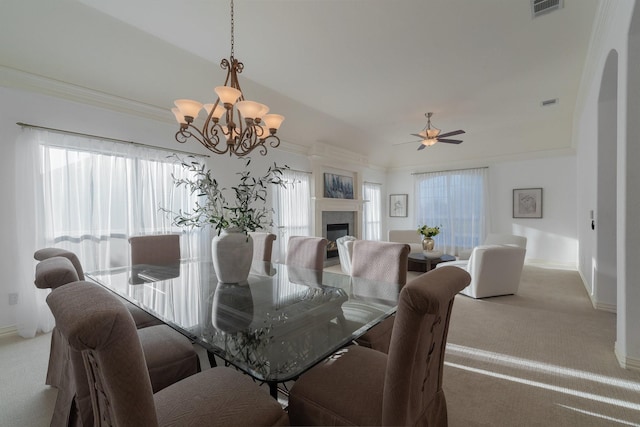 carpeted dining room with ceiling fan with notable chandelier