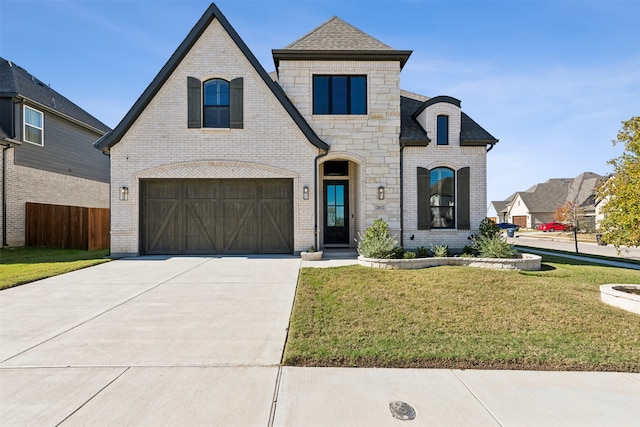 french country inspired facade featuring a front lawn and a garage