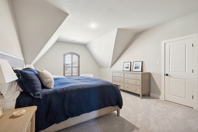 bedroom with light colored carpet and vaulted ceiling