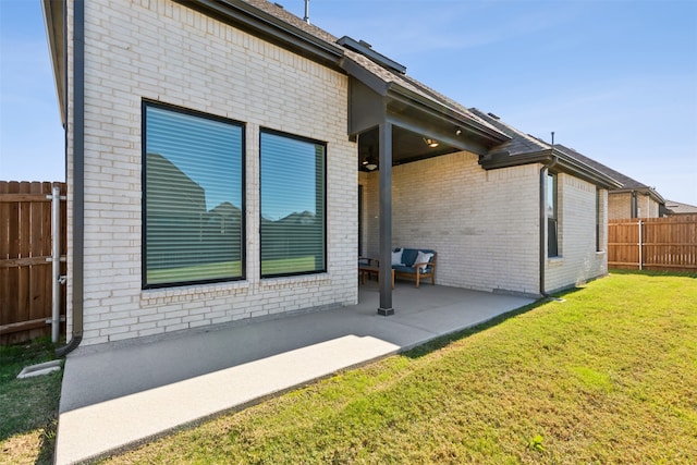 view of side of home with a yard and a patio