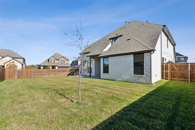 rear view of house featuring a yard