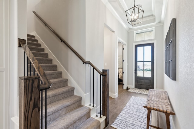 foyer entrance featuring a chandelier, a high ceiling, and dark hardwood / wood-style floors