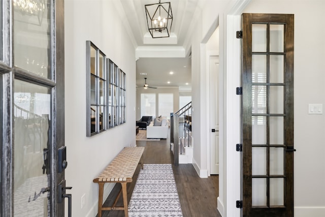 hallway with crown molding, french doors, dark wood-type flooring, and a chandelier