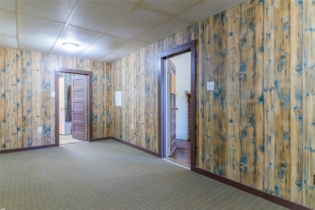 spare room with a paneled ceiling and carpet