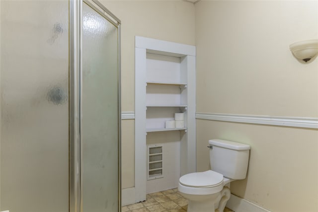 bathroom with toilet and a shower with door